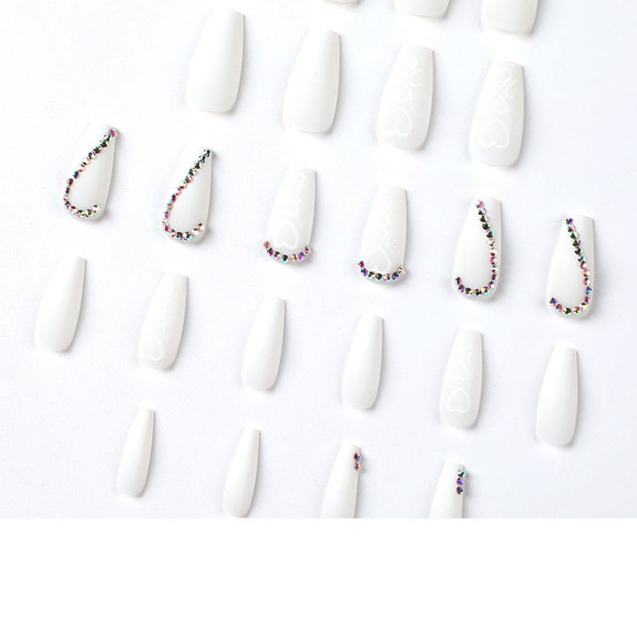 Kunstvolle Nagelverlängerungen mit Herzen-Design und Glitzerakzenten Karnz