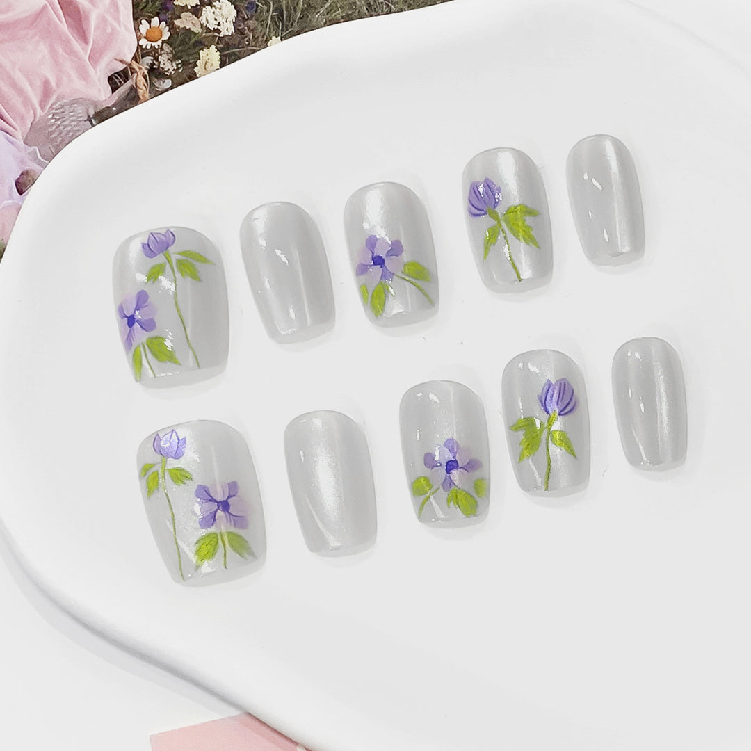 Kunstvolle Fingernägel mit floralen Akzenten Karnz
