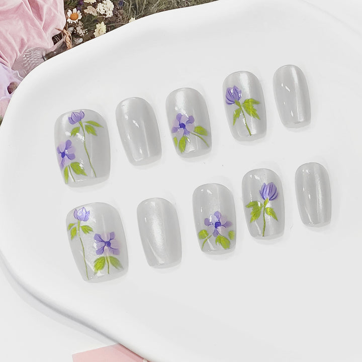 Kunstvolle Fingernägel mit floralen Akzenten Karnz