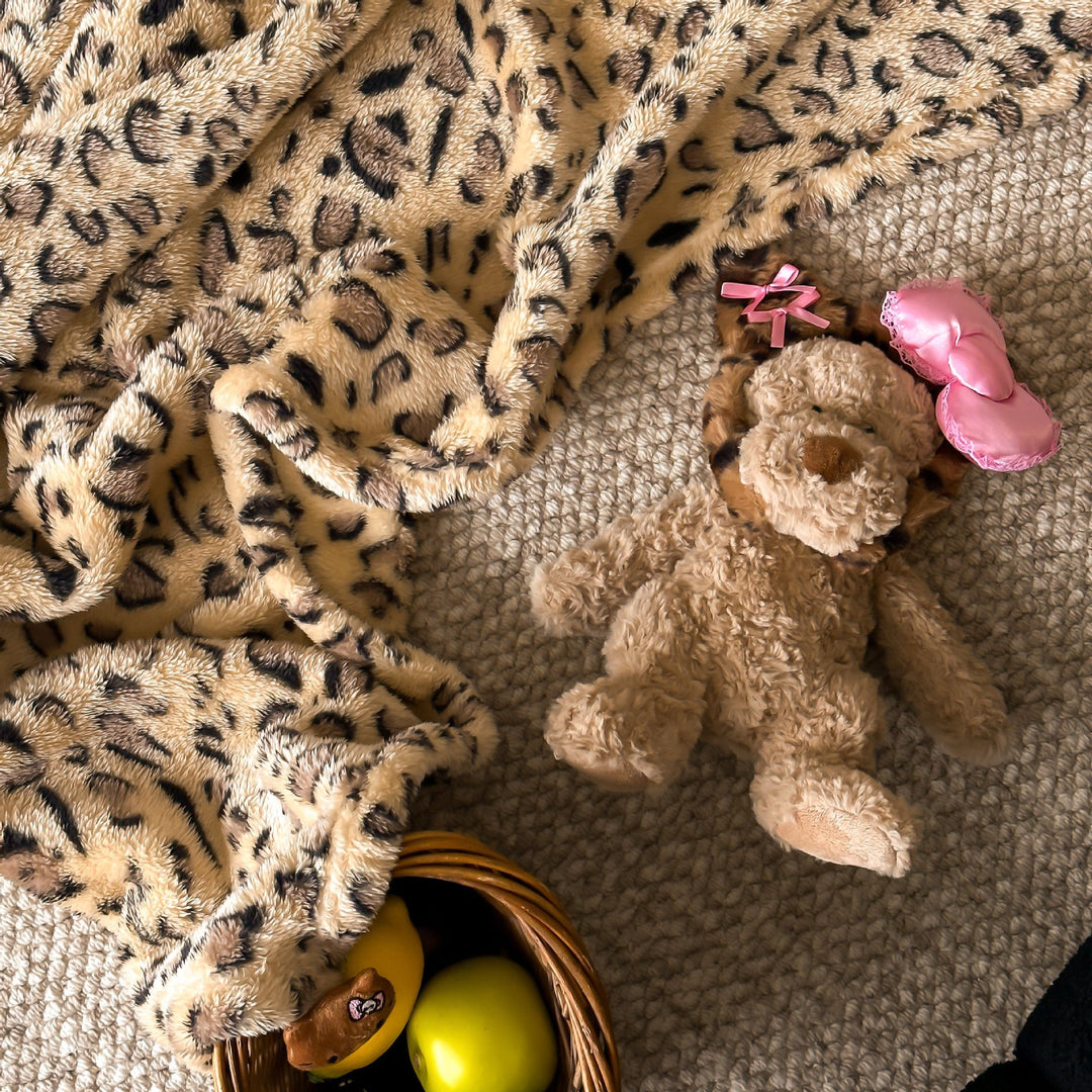 Kuschelige Wohndecke aus Microfleece mit Leo-Print und Plüschanhängern