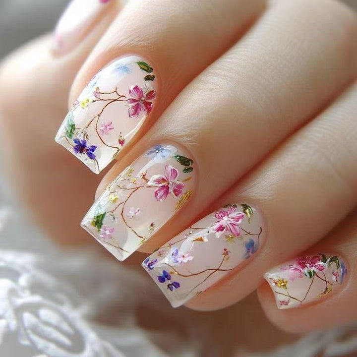 Kunstnagelset mit floralen Akzenten und transparentem Glanz Karnz