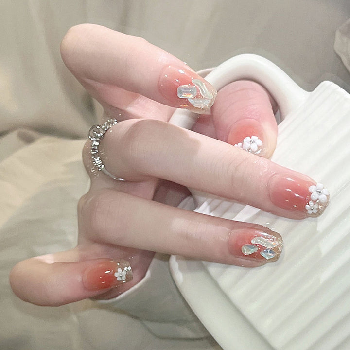 Kunstnagelset mit floralen 3D-Verzierungen und elegantem Glitzer Karnz