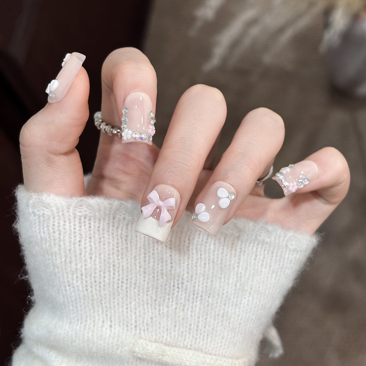 Dekoratives Nagelkunstset mit floralen Details und Schleifenakzenten