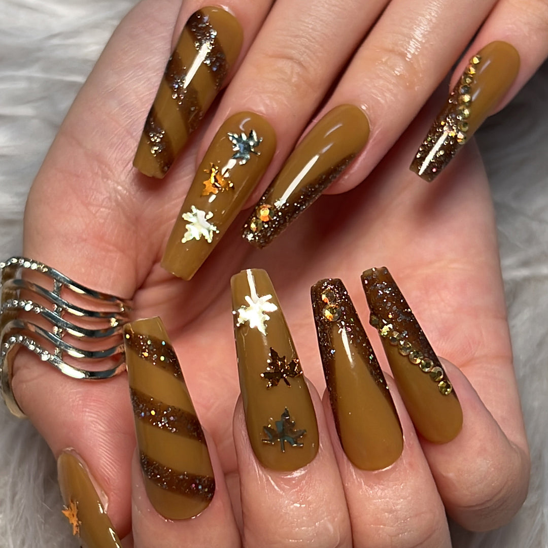 Kunstvolle Nagelkunst mit Glitter- und Blätterdesign Karnz