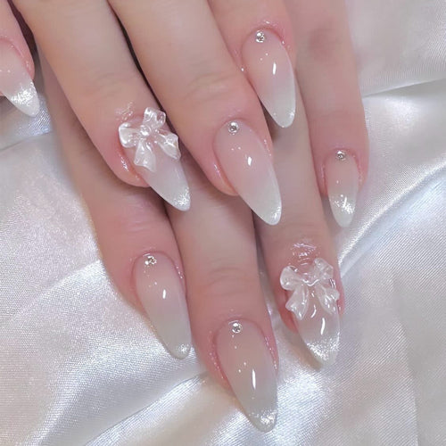 Elegante Stiletto-Nägel mit Glitzer- und Schleifenakzenten Karnz
