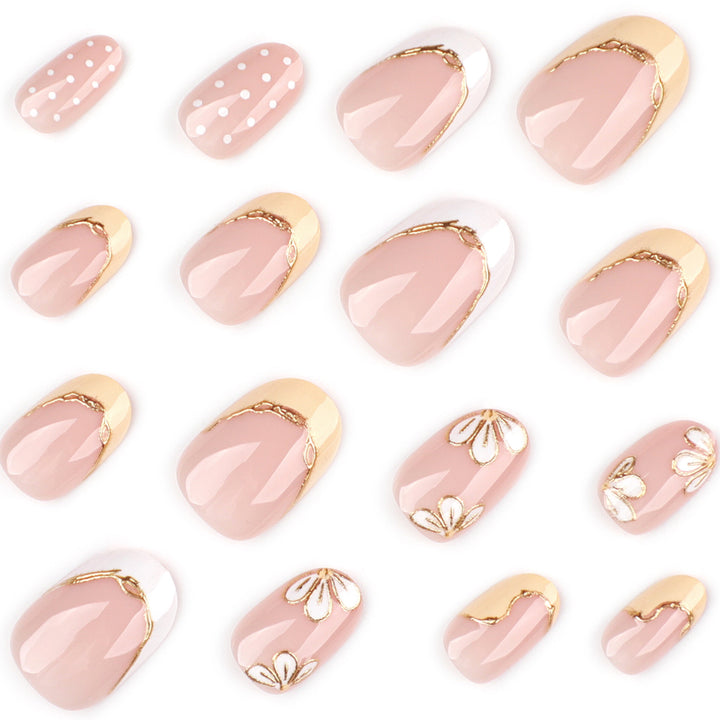 Kunstvolle Nagelverlängerungen mit floralem Design und eleganten Goldakzenten Karnz
