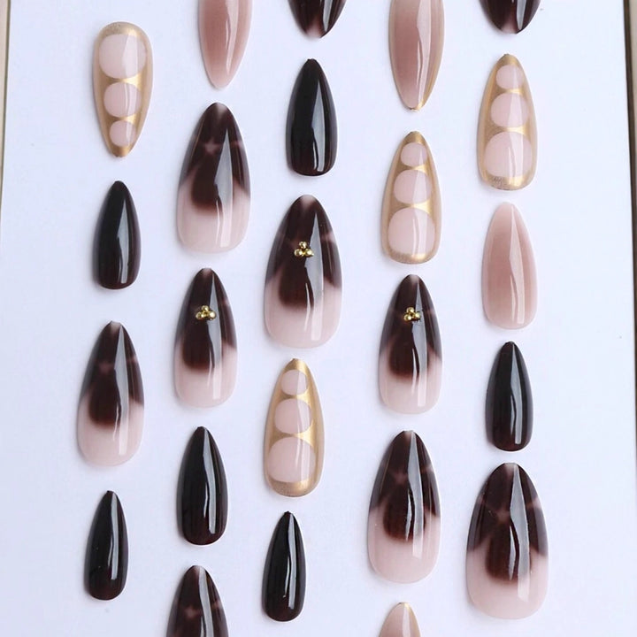 Kunstnagelset mit eleganten Ombre-Design und Goldverzierungen Karnz