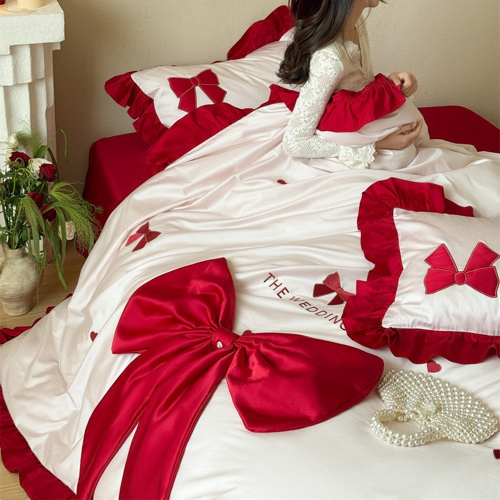 Romantische Bettwäsche-Garnitur mit XXL-Satin‑Schleife, Volant und bestickten Applikationen