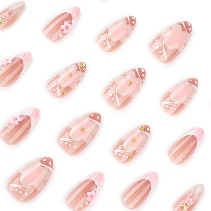 Kunstvolle Nagelverlängerungen mit Blütenmuster und Glitzerakzenten Karnz