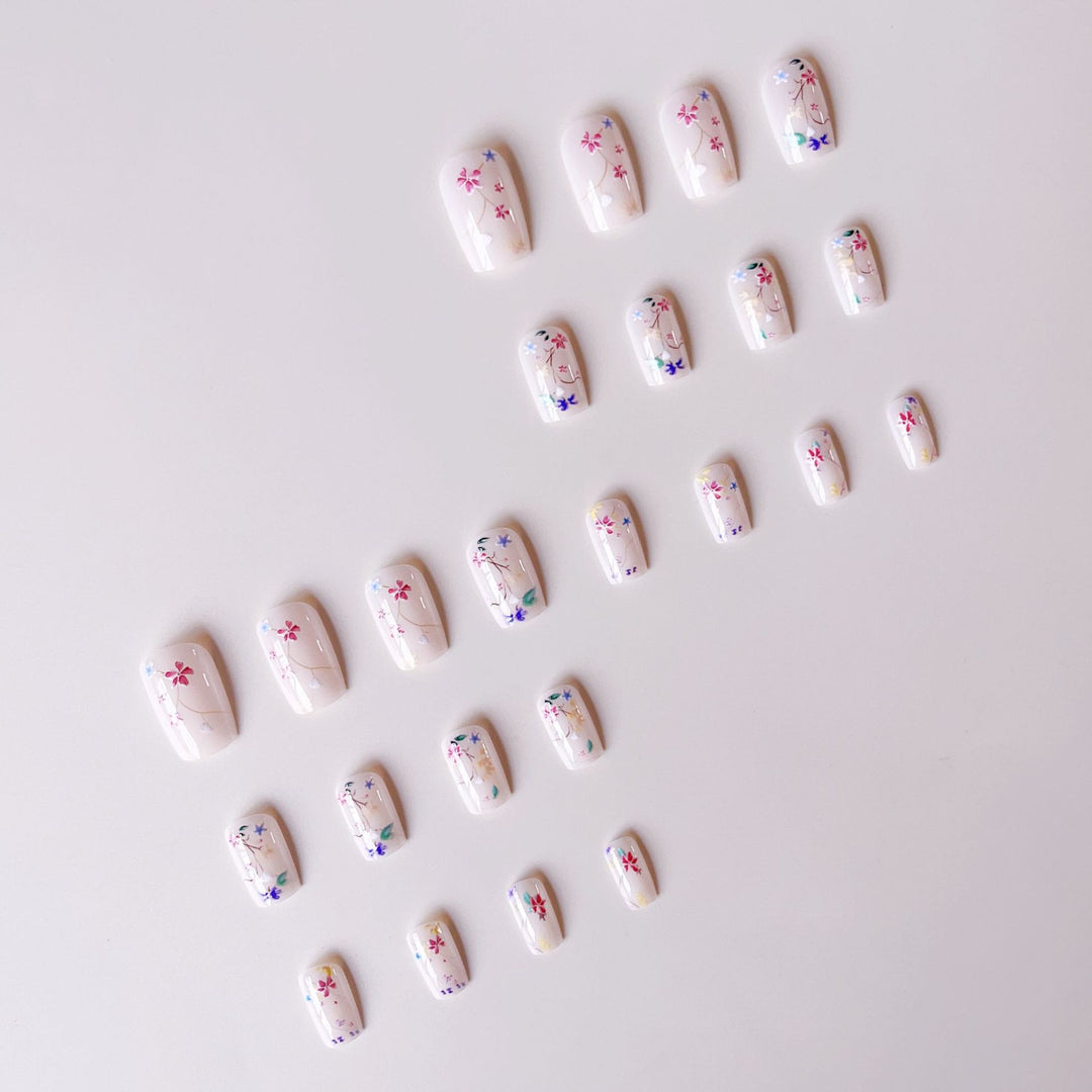Kunstnagelset mit floralen Akzenten und transparentem Glanz Karnz