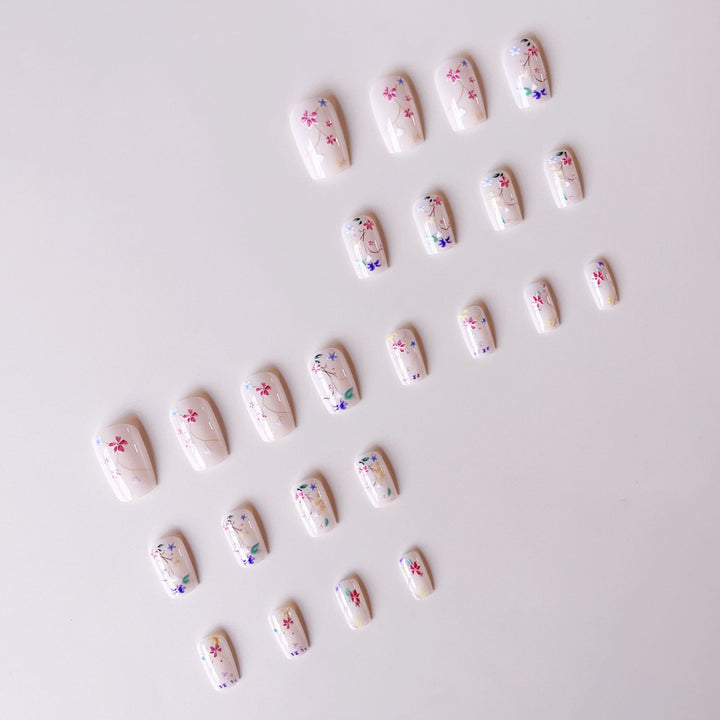 Kunstnagelset mit floralen Akzenten und transparentem Glanz Karnz