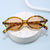 Damen modische Sonnenbrille mit ovalem Rahmen und goldenen Akzenten Karnz