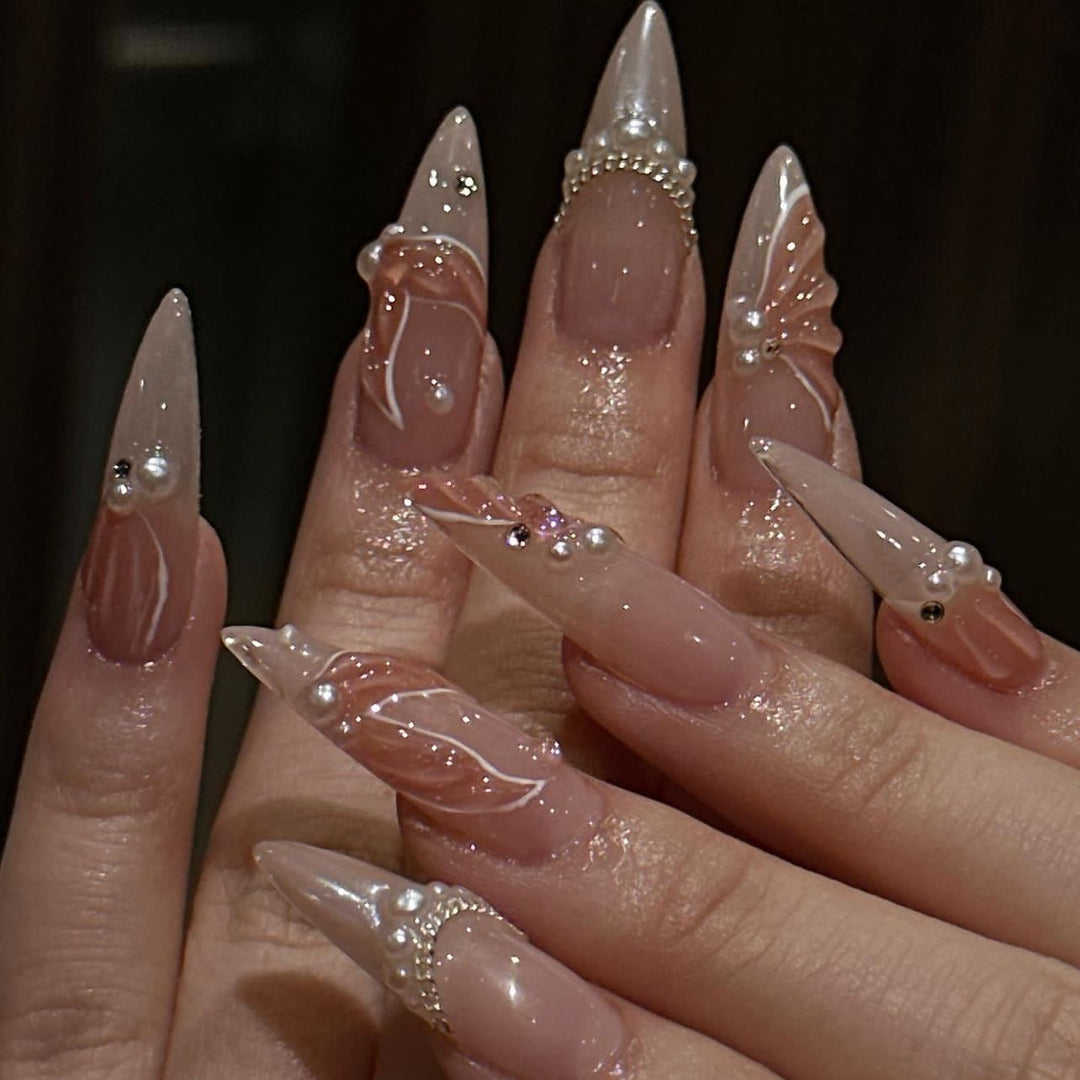 Kunstvolle Stiletto-Nägel mit Perlen- und Blumenverzierungen Karnz