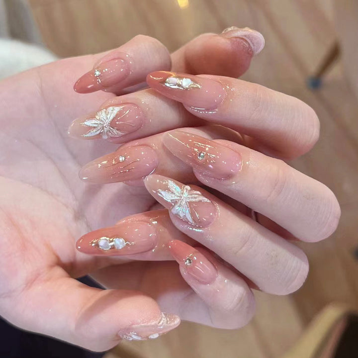 Künstliche Nagelverlängerungen mit floralen Motiven und Glitzerakzenten Karnz