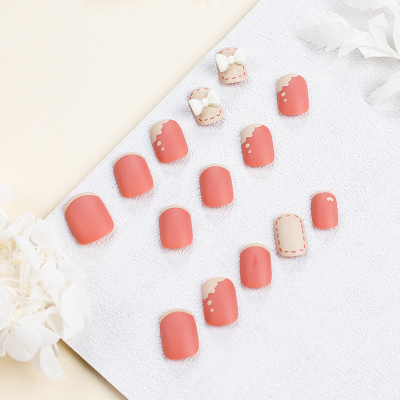 Kunstvolle Nagelnägel mit dekorativen Bogenmotiven und French-Spitzen Karnz