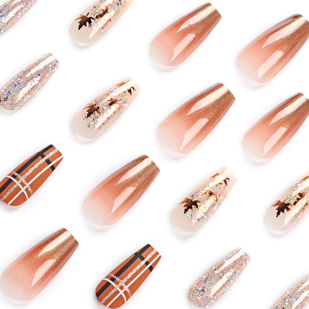Kunstvolle Nagelverlängerungen mit Glitzer- und Blattmotiven Karnz