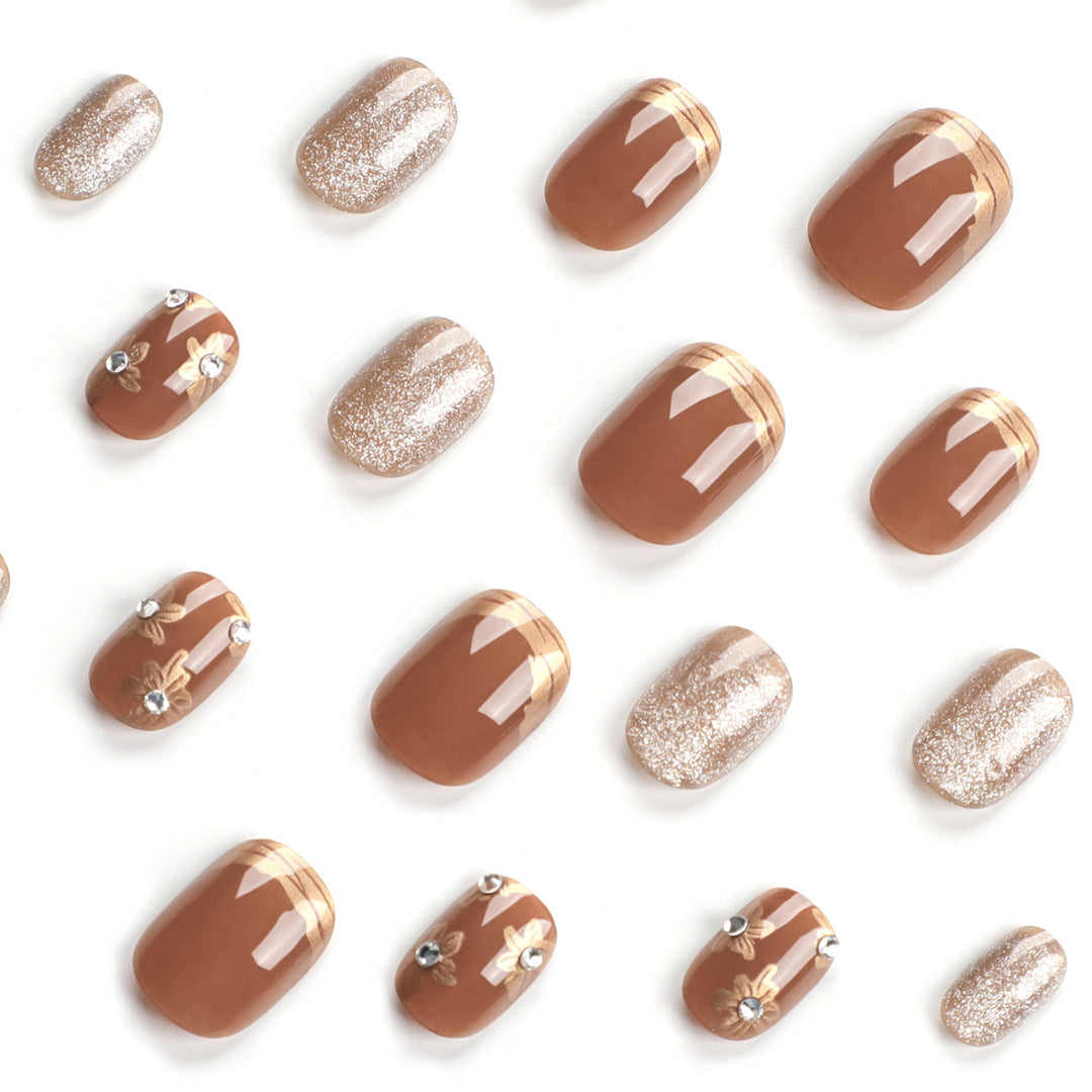 Elegante Nageldekoration mit Glitzer und floralen Akzenten Karnz