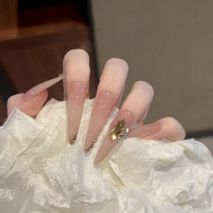 Künstlerische Stiletto-Nagelverlängerungen mit Edelsteinakzenten