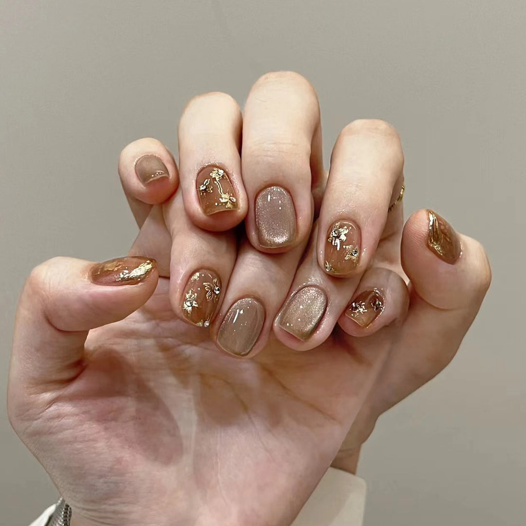 Elegante Nageldekoration mit Glitzer und floralen Akzenten Karnz