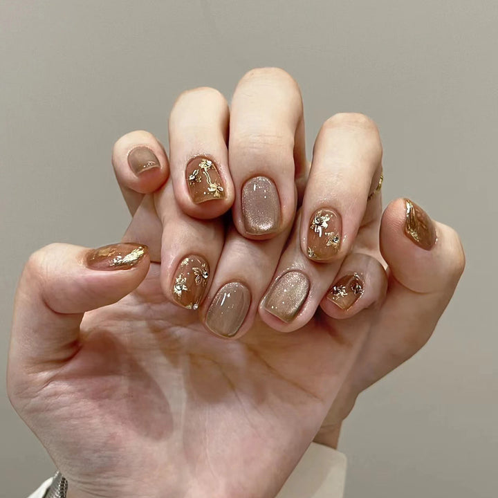 Elegante Nageldekoration mit Glitzer und floralen Akzenten Karnz