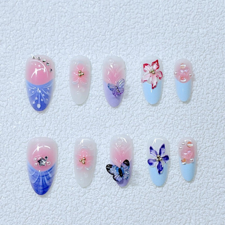 Kunstvolle Nagelkunst mit Blumendetails und Schmetterlingen Karnz