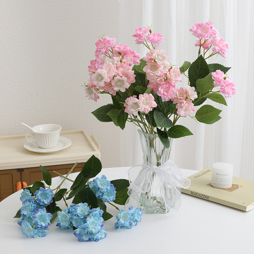 Kunstblumenarrangement mit zarten weißen Blüten Karnz