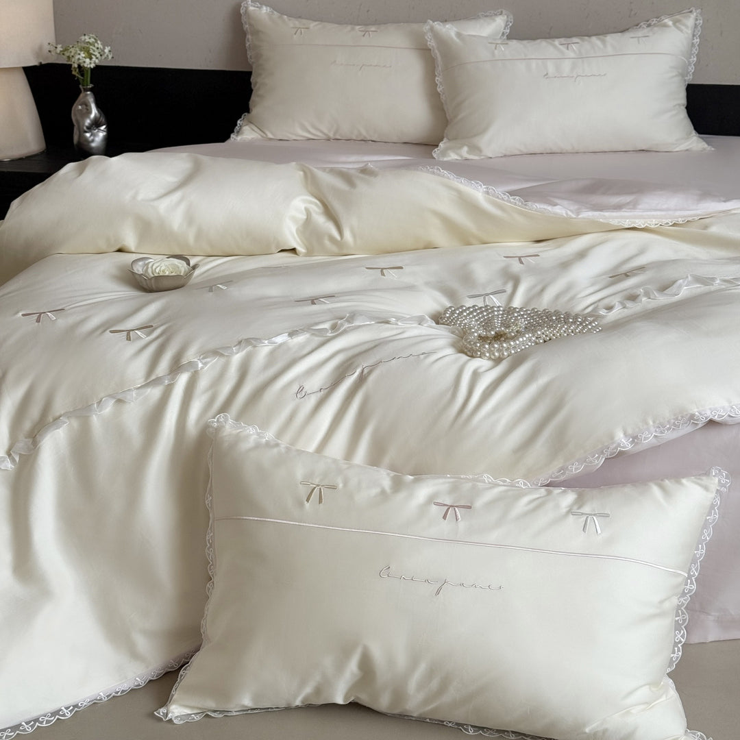 Elegante Bettwäschegarnitur aus seidig-feinem Satin mit bestickten Schleifen und Spitzenbordüre