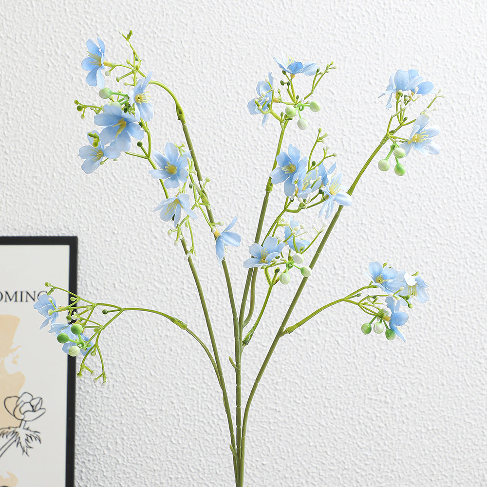 Künstlicher Blütenzweig mit zarten blauen Blumen und grünen Beeren Karnz