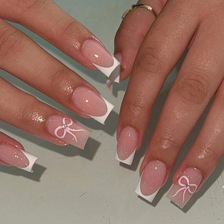 Kunstnagelset mit eleganten Schleifen- und Glitzerakzenten Karnz