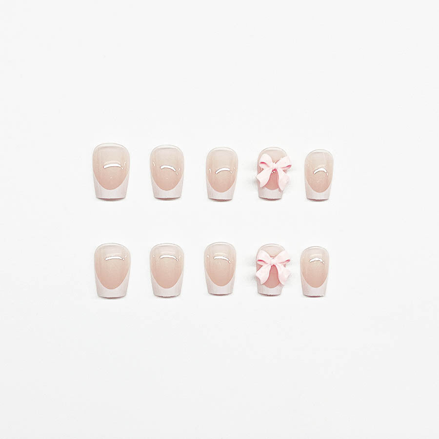 Dekorative French Tip Nagelverlängerungen mit Schleifenakzenten Karnz