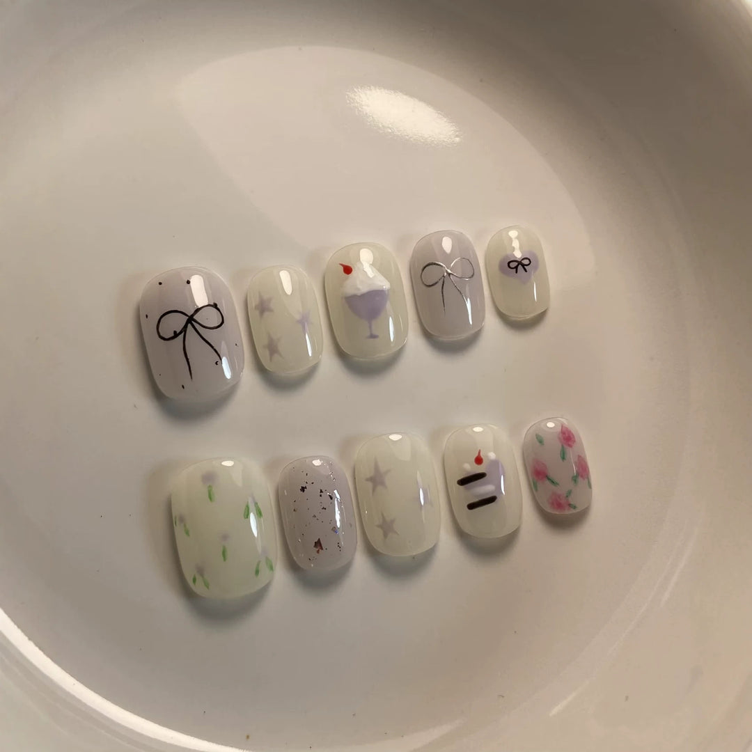 Künstlerisches Press-On Nagelkunstkset mit niedlichen Kuchen- und Banddesigns