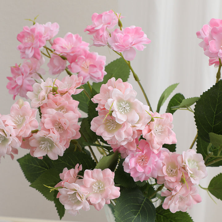 Kunstblumenarrangement mit zarten weißen Blüten Karnz