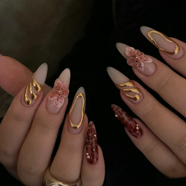 Kunstvolle Stiletto-Nägel mit eleganten Blumendesigns und Glitzerakzenten Karnz