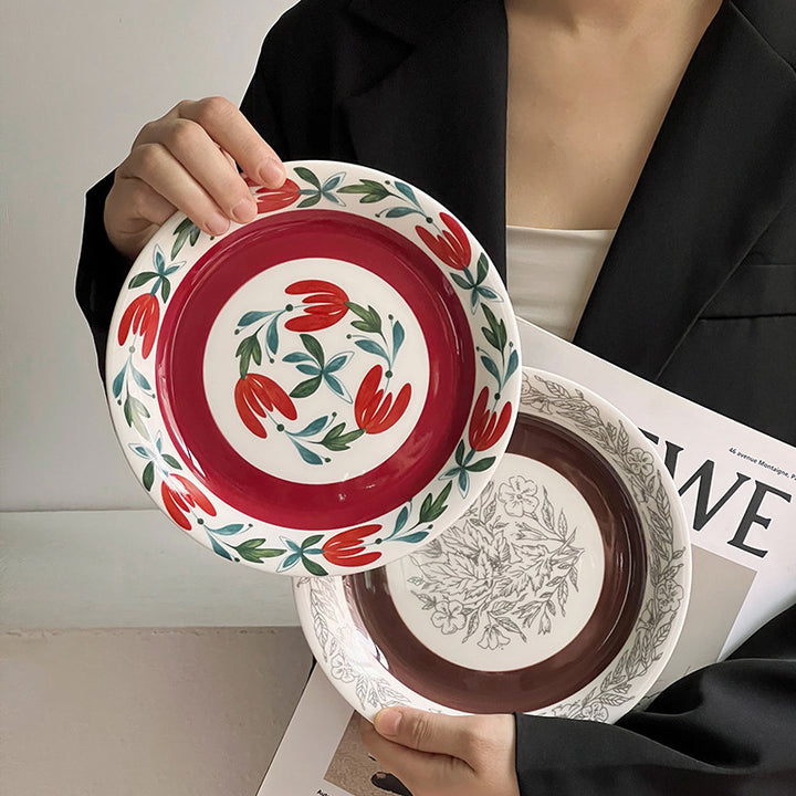 Tiefer Porzellanteller mit floraler Randornamentik und kontrastierendem Innenspiegel
