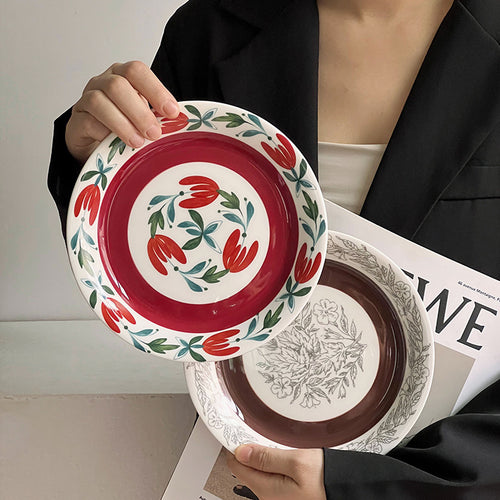 Tiefer Porzellanteller mit floraler Randornamentik und kontrastierendem Innenspiegel