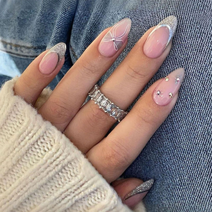 Kunstnagelset mit glamourösen Glitzer- und Blütenakzenten Karnz