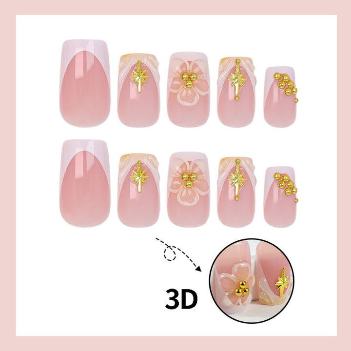 Kunstnagelset mit zarten Blüten- und Goldverzierungen Karnz