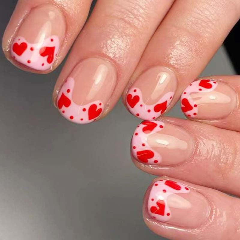 Kunstvoll gestaltete Nagelspitzen mit Herzmotiven Karnz