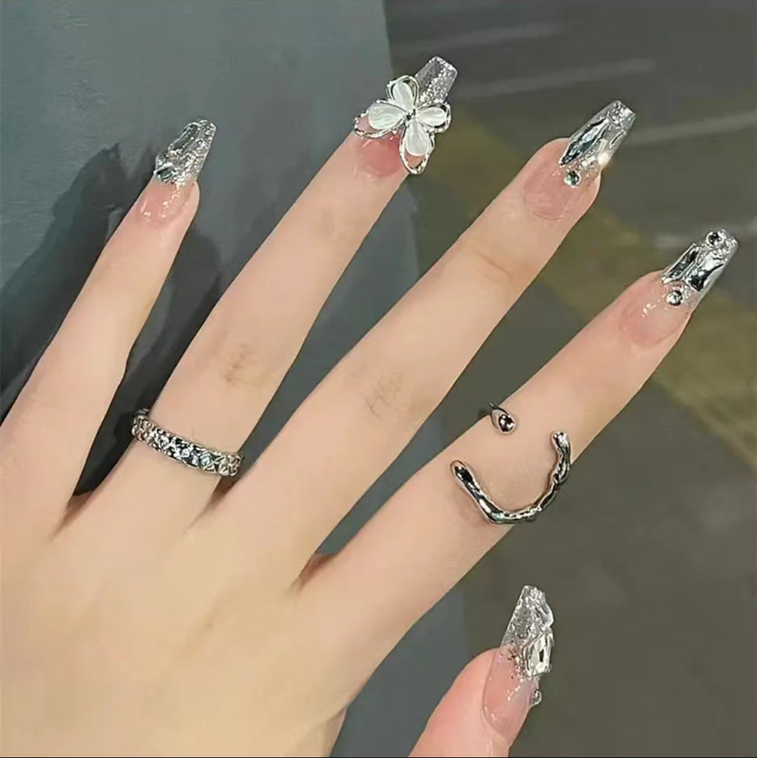 Kunstvolle Nagelkunst mit Glitzer- und Schmetterlingselementen Karnz
