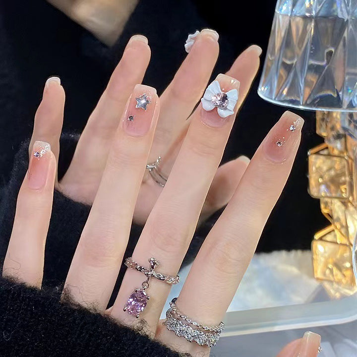 Kunstvolle Nagelspitzen mit floralen und glitzernden Akzenten Karnz