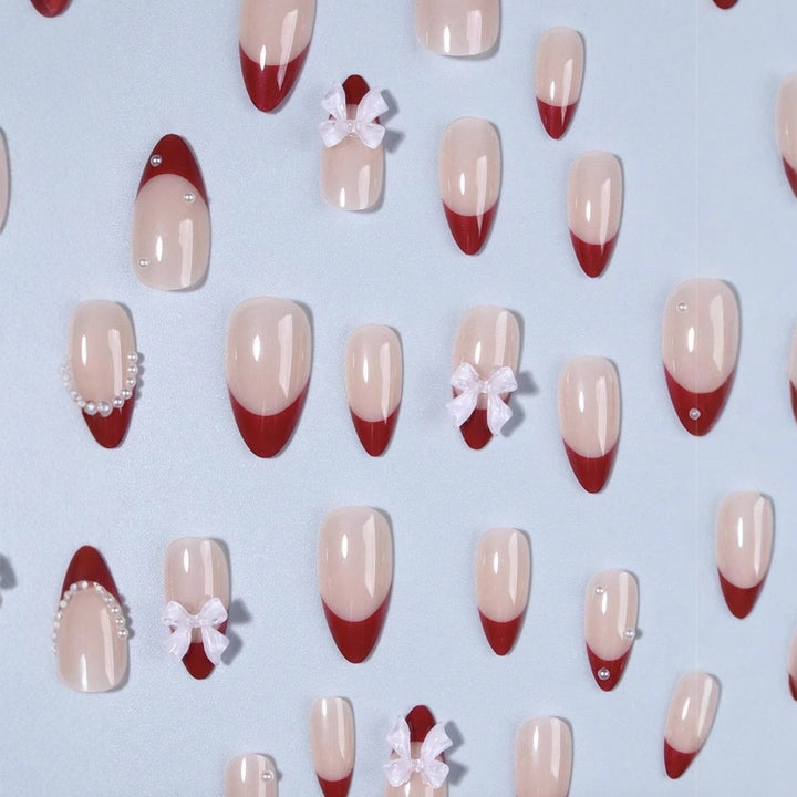 Kunstnagelset mit glamourösen Strass- und Schleifenverzierungen Karnz