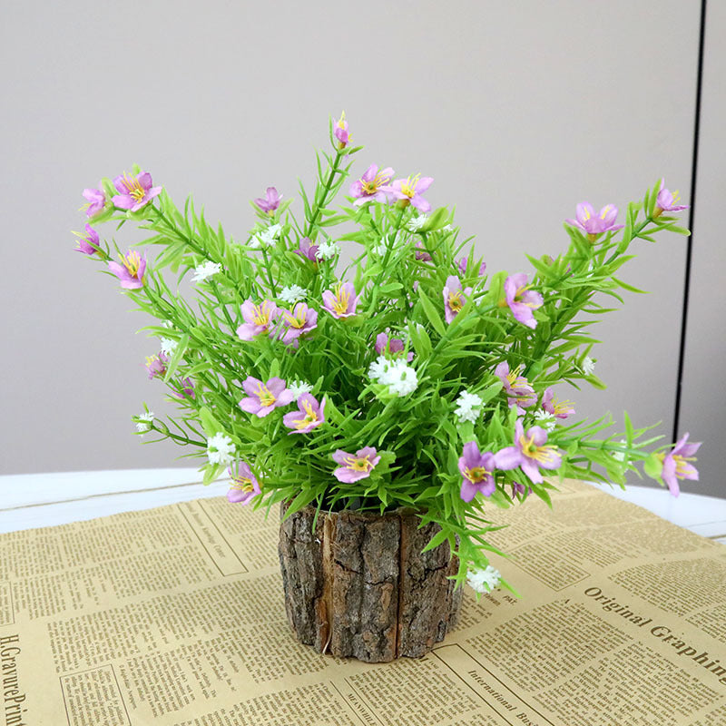 Lebensnahe florale Anordnung mit rustikalem Holztopf