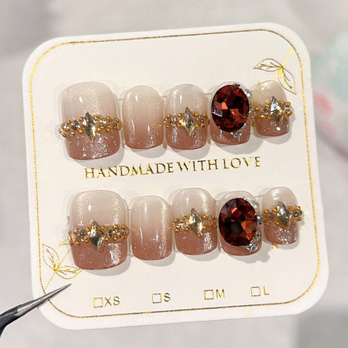 Künstliche Nagelkunst mit Glitzer- und Schmuckverzierungen Karnz
