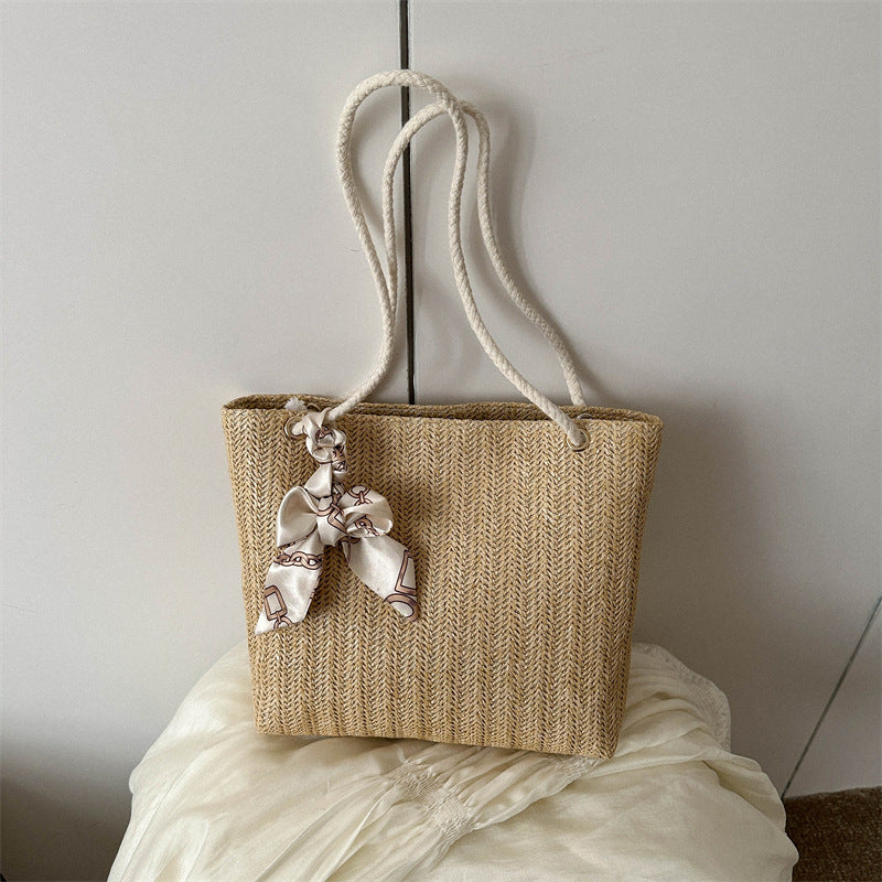 Geflochtene Strohtasche mit dekorativem Schal