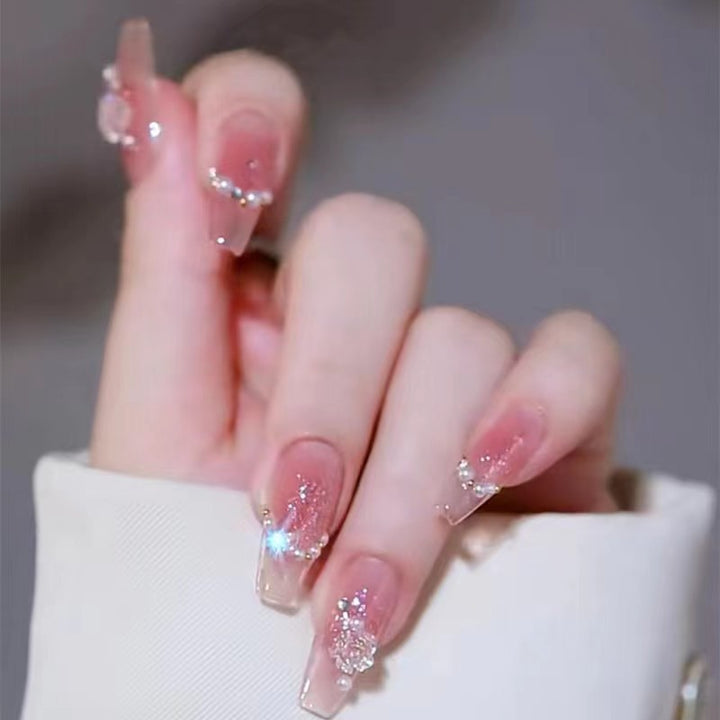 Kunstvolle Nagelkunst mit Schmetterlings- und Perlendetails Karnz