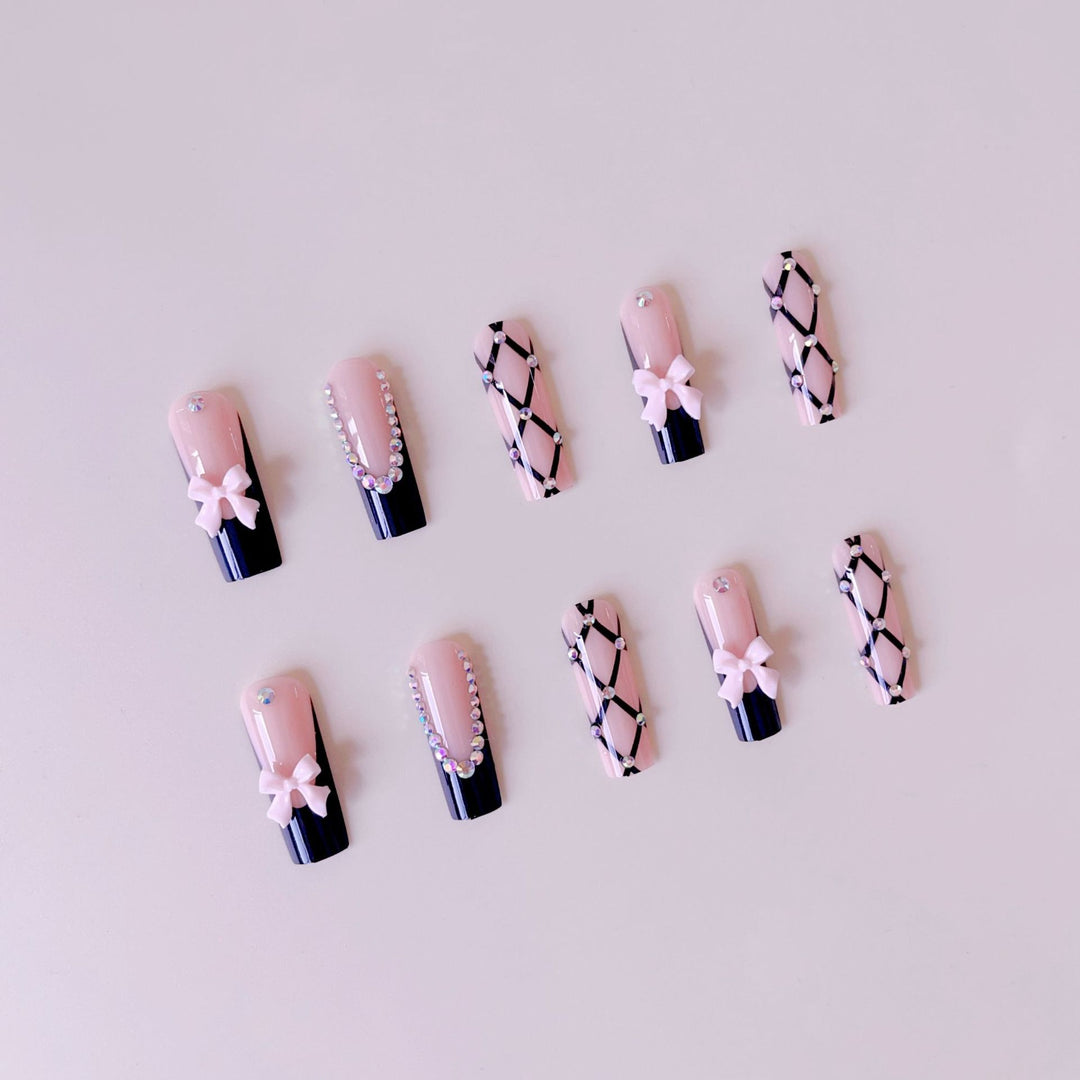 Kunstnagelset mit glamourösen Strass- und Schleifenakzenten Karnz