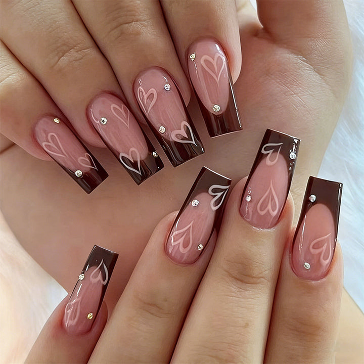 Elegante Kunstnägel mit Herz-Muster und Glitzerakzenten Karnz