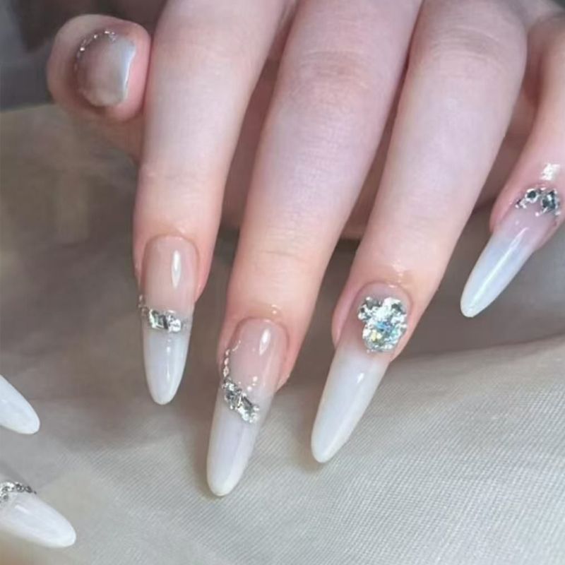 Kunstnagelset mit eleganten Spitzen und glamourösen Strassakzenten Karnz