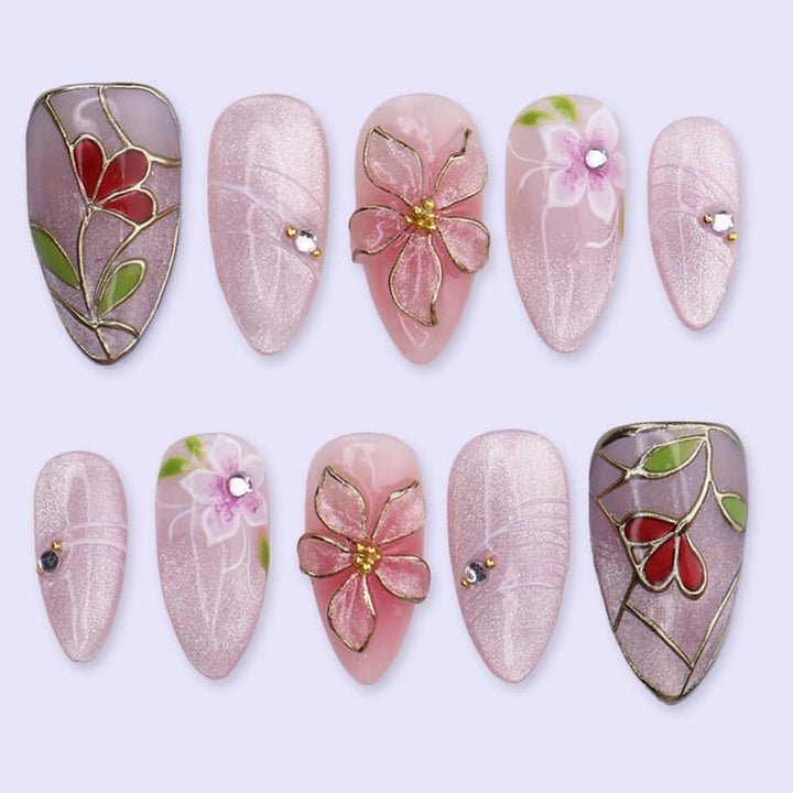 Kunstnagelset mit filigranen floralen Verzierungen und glänzenden Details Karnz