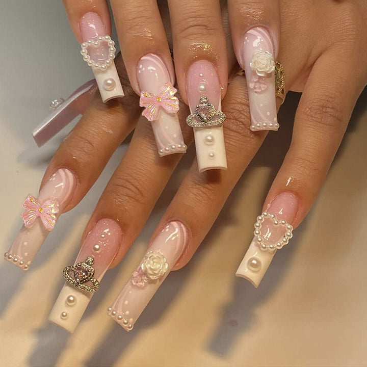 Kunstvolle Nagelspitzen mit Perlen- und Schleifenmotiven Karnz
